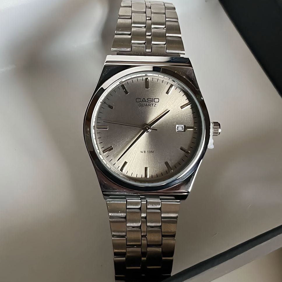 Silver circular Casio watch