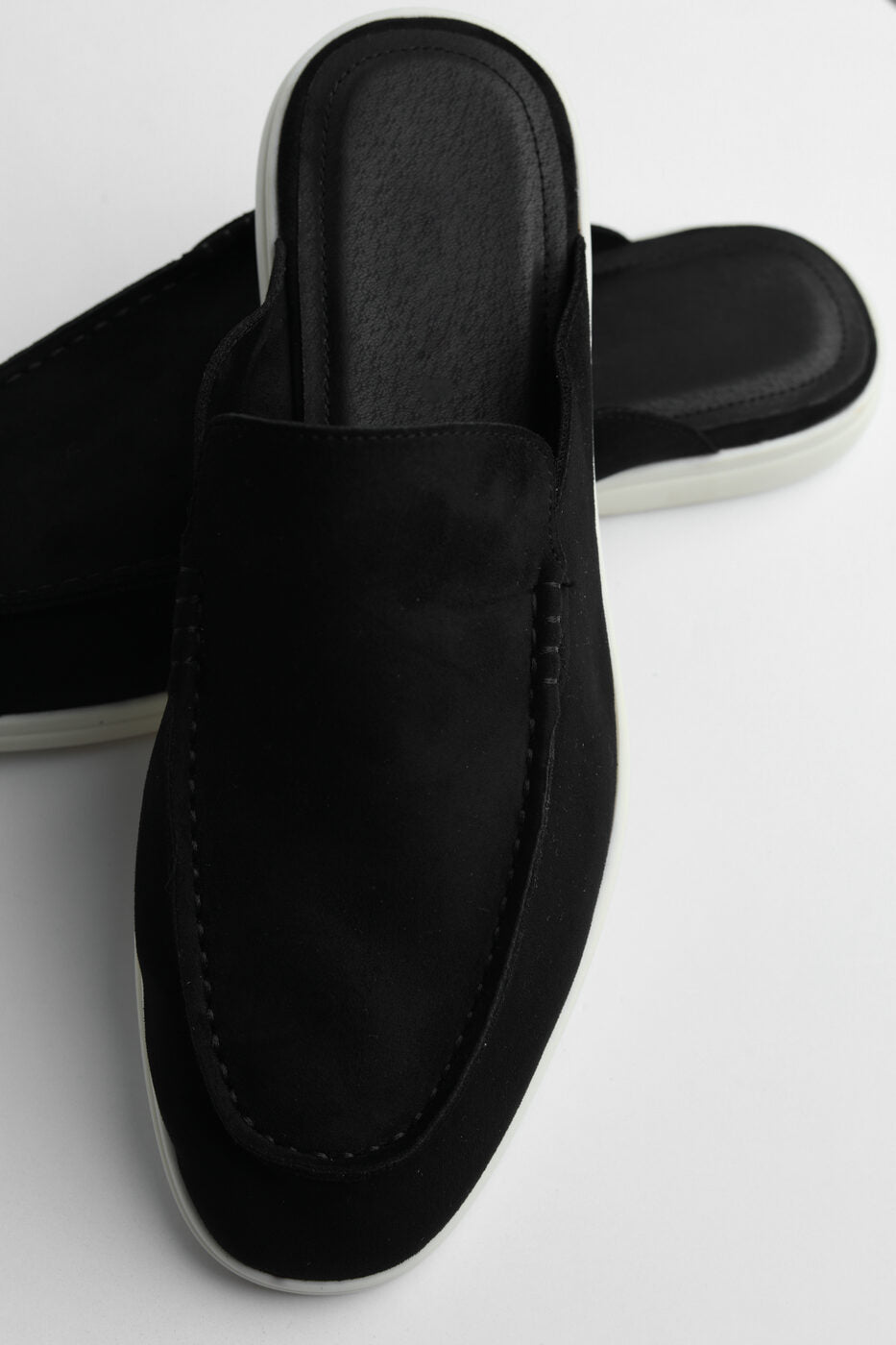 Belugga Dune Mule in black suede, angled view on white sole